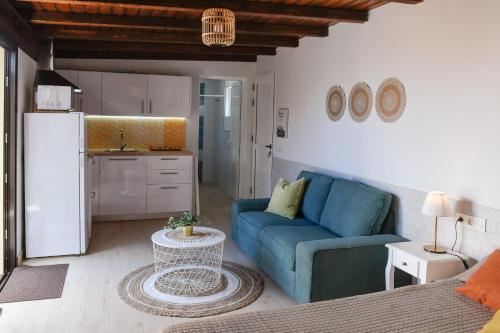 a living room with a blue couch and a kitchen at Mini Loft Tesa in Mácher