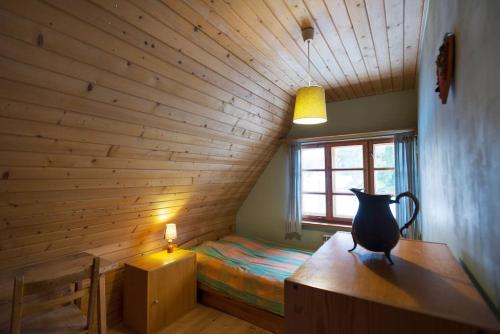 a room with a bed and a vase on a desk at Dom na Pawlikach in Rzepiska
