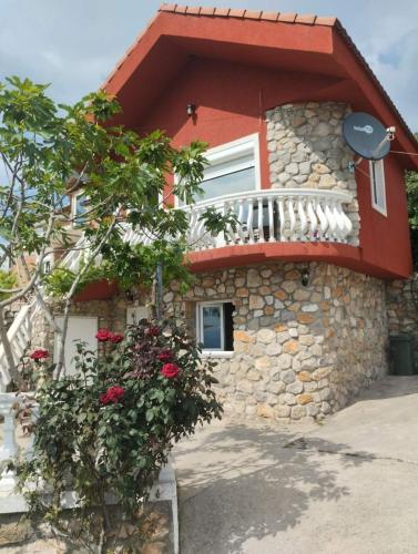 a house with a balcony on the side of it at WOODSTONE APARTMAN in Podgorica