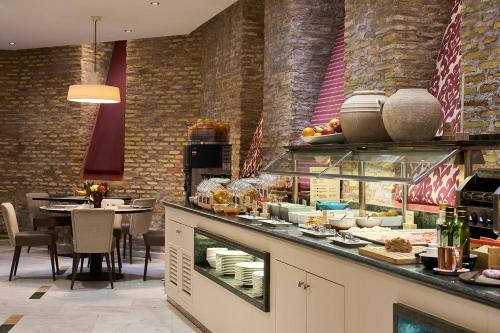 a restaurant with a counter with food on it at Catalonia El Pilar in Zaragoza