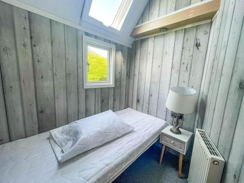 um quarto com uma cama com um candeeiro e uma janela em Lovely 8 Berth Caravan At Hopton Holiday Park To Hire In Norfolk Ref 80017l em Great Yarmouth