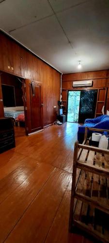 a living room with a bed and a wooden floor at Pai Yard Guest House in Pai