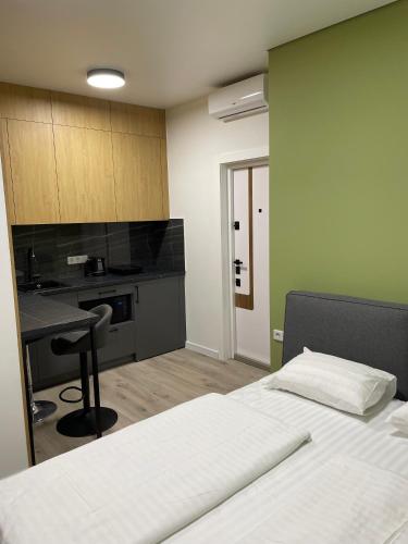 118 apartments في كييف: غرفة نوم بسرير ومكتب ومطبخ