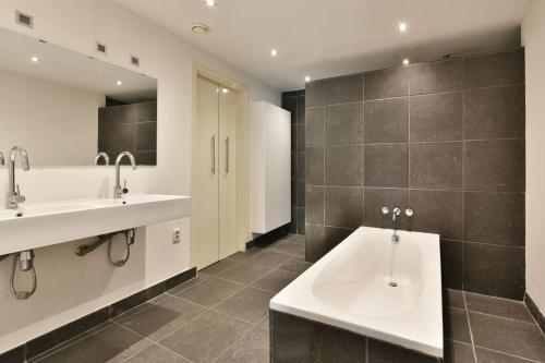 La salle de bains est pourvue de 2 lavabos et de 2 miroirs. dans l'établissement Peulenstraat 224, à Hardinxveld-Giessendam