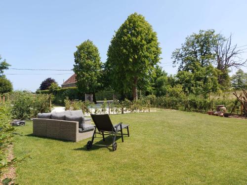 a chair sitting in the grass next to a couch at In 't Wiel Oudenaarde in Oudenaarde