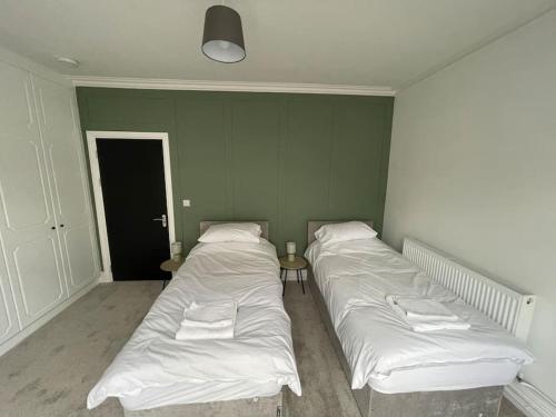 two beds in a room with a wall at The Mount in Swansea