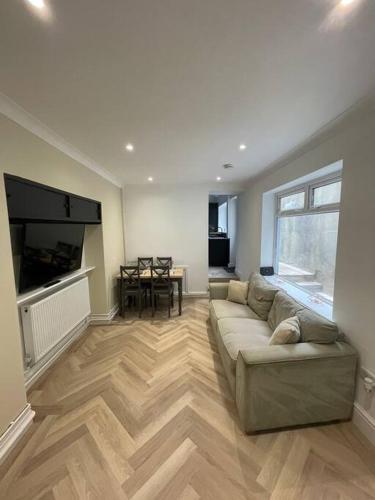 a large living room with a couch and a television at The Mount in Swansea
