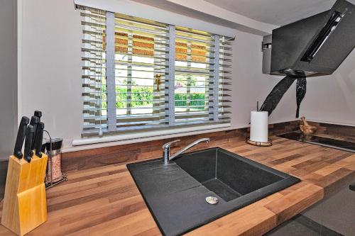 a kitchen with a sink and a tv and a window at Finest Retreats - Pemberley Cottage 