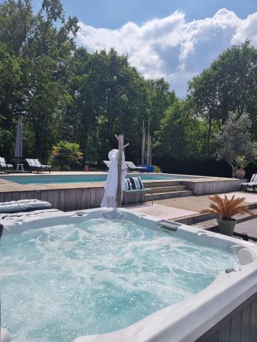 une baignoire avec une statue de croix dans l'établissement La Parenthèse du Las, Maison d'hôtes avec Piscine et Spa, à Saint-Jean-dʼIllac