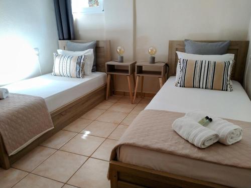 sypialnia z 2 łóżkami i ręcznikami w obiekcie Drystone Cottage w mieście Stavros