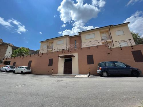 a building with two cars parked in a parking lot at Sotto le Mura, appartamento Loggia in Siena