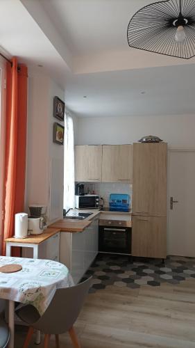 une cuisine avec des armoires en bois et une table à l'intérieur dans l'établissement MENTON A 2 pas des plages de sable et du centre ville beau 3 pièces pour 3 personnes, à Menton