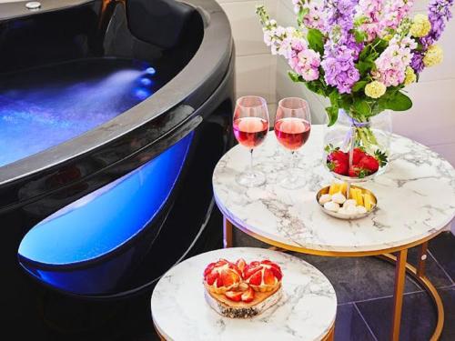 two tables with glasses of wine and a vase of flowers at GORSKI RESORT Lux Apartments Jacuzzi & Sauna in Poronin