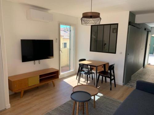 Il comprend un salon doté d'une table et d'une télévision à écran plat. dans l'établissement Appartement Côte bleue accès plage, à Sausset-les-Pins