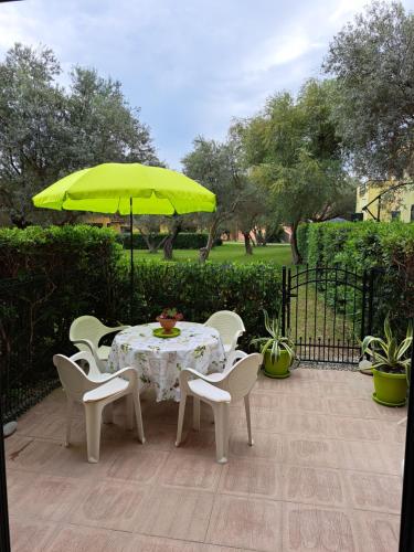 un tavolo e sedie con ombrellone giallo su un patio di Casa Solaris a SantʼAndrea Apostolo dello Ionio