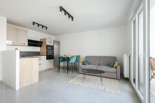 une cuisine et un salon avec un canapé et une table dans l'établissement Dans le Pré by Plaza, à Chessy