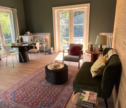 un soggiorno con divano e tavolo di Suites Elswoutshoek a Overveen