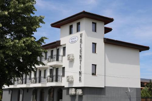 un edificio blanco con un reloj en él en SPA Guest House Valentina, en Yagoda