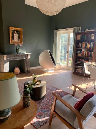 a living room with green walls and a table and chairs at Suites Elswoutshoek in Overveen