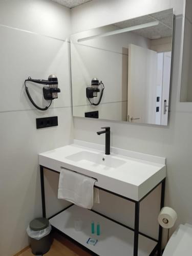 a bathroom with a sink and a mirror at Hotel Costa Brava in Roses