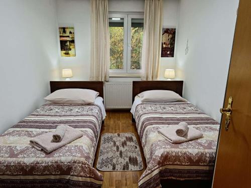 two beds in a room with a window at Haus Viktoria near Banja Luka in Banja Luka