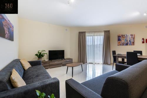 - un salon avec deux canapés et une télévision dans l'établissement Serene 2BR Apartment with Picturesque Views by 360 Estates, à Marsaxlokk