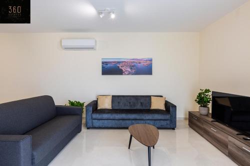 a living room with a couch and a tv at Serene 2BR Apartment with Picturesque Views by 360 Estates in Marsaxlokk