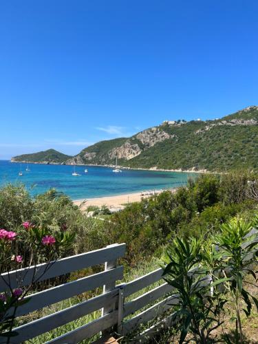 a bench on a beach with a view of the ocean at Hamre Apartments (Nicholas) in Agios Georgios Pagon