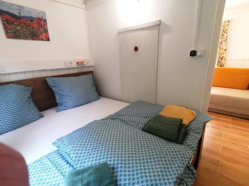 1 dormitorio con 1 cama con almohadas azules y verdes en Barkóca és Szépkilátás Vendégház / Cabin en Kismaros