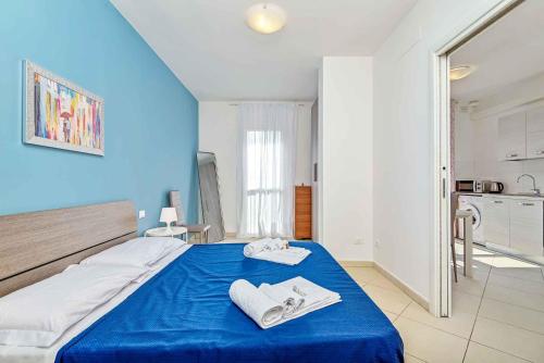 a bedroom with a blue bed with towels on it at La Spiga in Trebiano