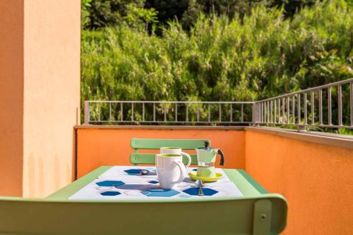 a green table with a tea set on a balcony at La Spiga in Trebiano