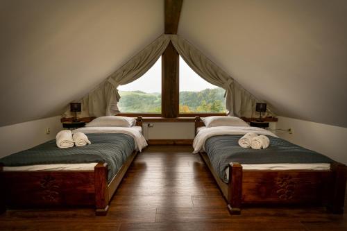2 camas en un ático con ventana en Janasiówka en Kamesznica