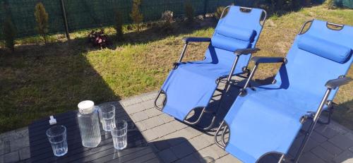 a blue picnic table with wine glasses on it at Apartament Nowy Władek 1 in Władysławowo