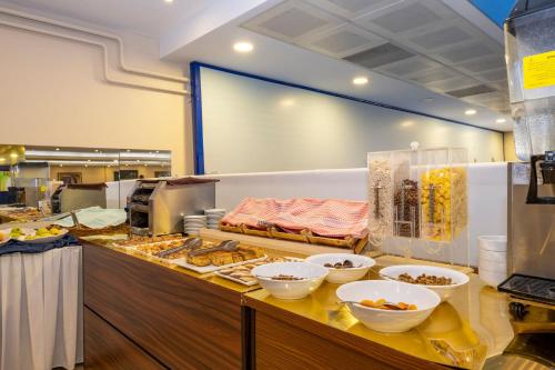 a buffet line with bowls and plates of food at Harmony Hotel Merter & SPA in Istanbul