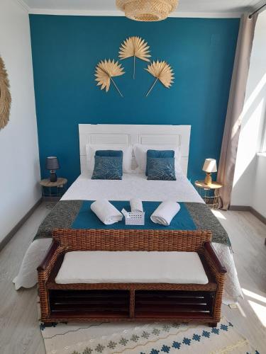 a bedroom with a large bed with a blue wall at Casa Chanel in Figueira da Foz