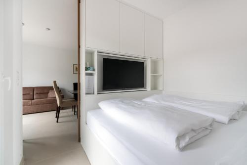 um quarto branco com uma cama e uma televisão em Ruhig, hell und neu mit Garage em Viena