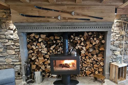 a fireplace with a fire inside of it at La ferme de Jouane in Besse-et-Saint-Anastaise