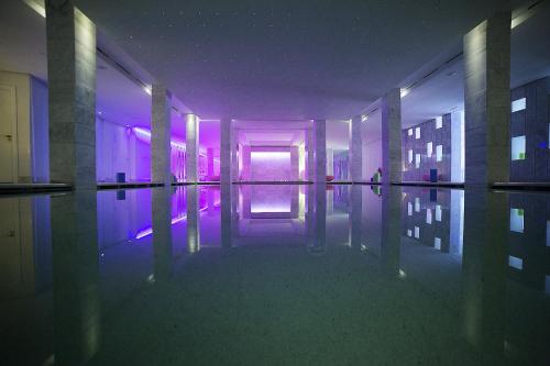 a room with a pool of water and purple lights at Cesar Resort & Spa in Marrakech