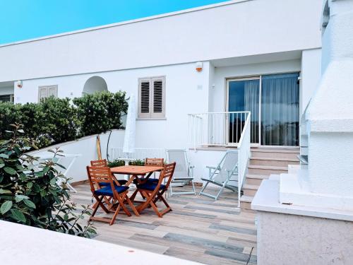 a patio with two chairs and a table on a house at Pescoluse Apartments in Marina di Pescoluse