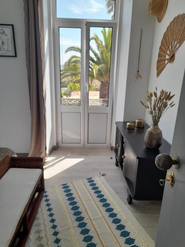 a room with a door and a table and a window at Casa Chanel in Figueira da Foz