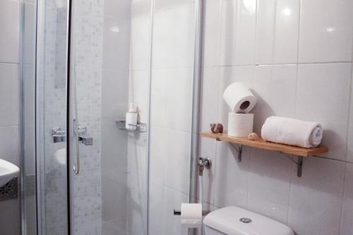 a bathroom with a shower and a toilet and towels at Vale a Pena - Alojamento Local in Trancoso