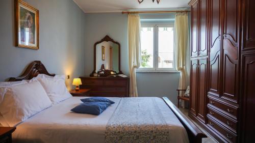 een slaapkamer met een bed, een dressoir en een spiegel bij SUNNY HOUSE in Diano dʼAlba