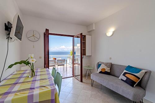 ein Wohnzimmer mit einem Tisch und einem Sofa in der Unterkunft Beachfront Villa Tempera with Seaview in Blato