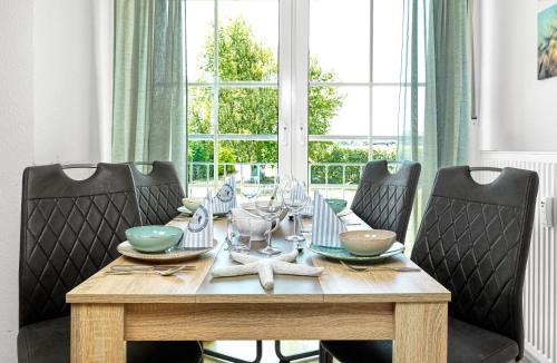 una mesa de comedor con 4 sillas alrededor en Haus Sonnenschein Sonnenwinkel, en Poel