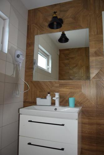 a bathroom with a white sink and a mirror at Morze nad Morze in Dąbki