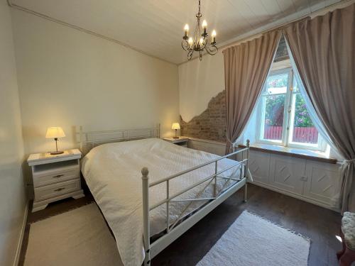 a bedroom with a bed and a window and a chandelier at Aadma Guesthouse in Hiiumaa