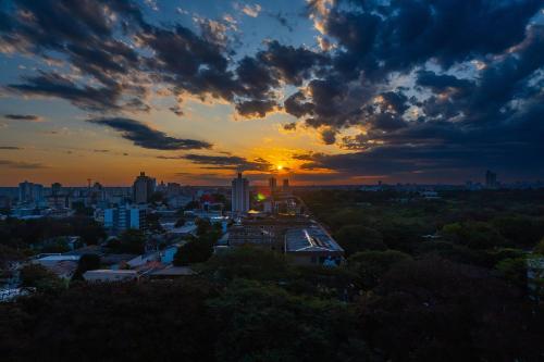 a view of a city with the sun setting at ibis budget Foz do Iguaçu in Foz do Iguaçu