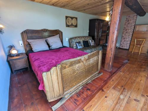 a bedroom with a large bed with a wooden floor at Grande maison de village in Villedaigne