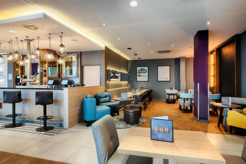 a restaurant with tables and chairs and a bar at Premier Inn Leipzig City Hahnekamm in Leipzig
