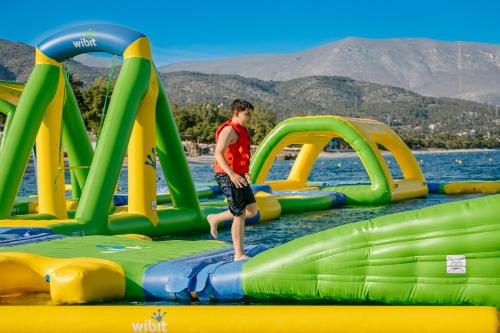 エレトリアにあるBrown Beach Evia Island, All Inclusive in Eretria, a member of Brown Hotelsの水中の筏に立っている少年